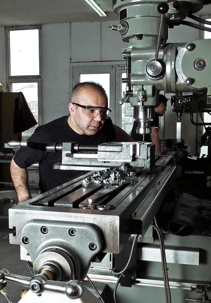 Man working on large machine metal