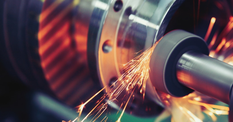 Precision grinding operation being performed on an industrial roller during repair and refurbishment.